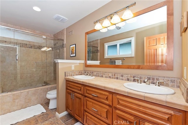 bathroom featuring toilet, vanity, and decorative backsplash