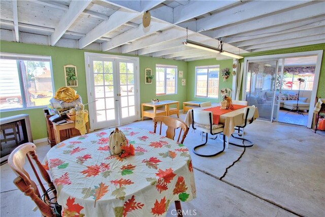 sunroom / solarium featuring beam ceiling and french doors