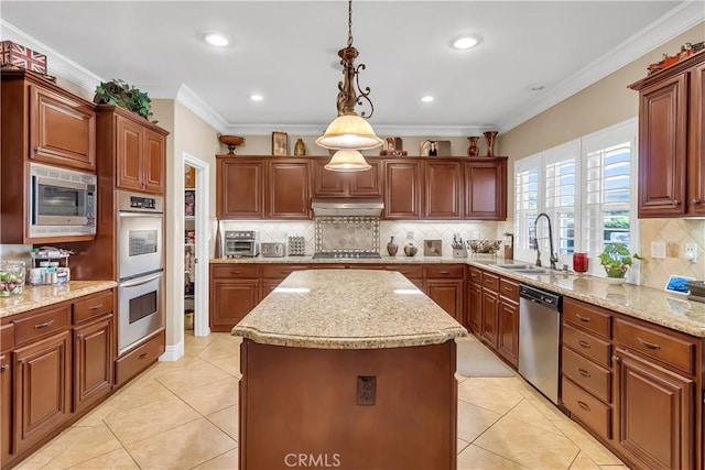 kitchen with sink, hanging light fixtures, stainless steel appliances, a kitchen island, and light tile patterned flooring