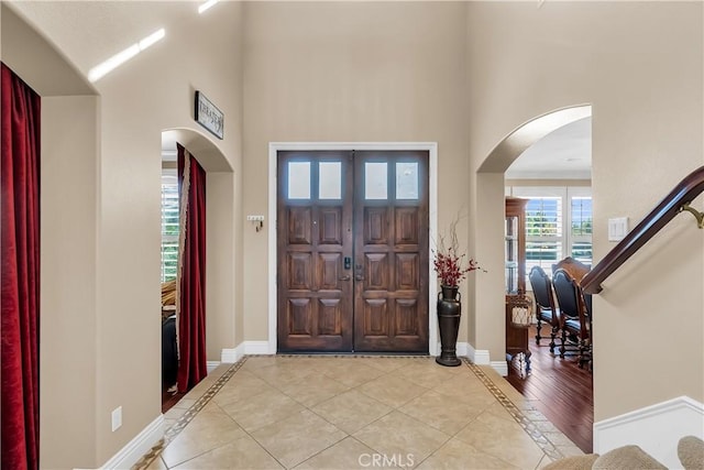 foyer with a towering ceiling and light hardwood / wood-style floors