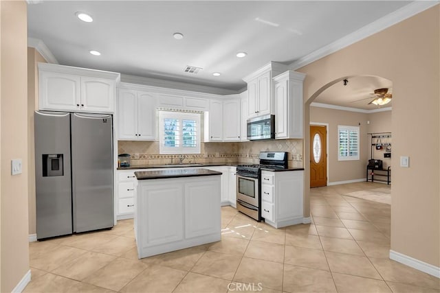 kitchen featuring appliances with stainless steel finishes, white cabinetry, ceiling fan, and a healthy amount of sunlight