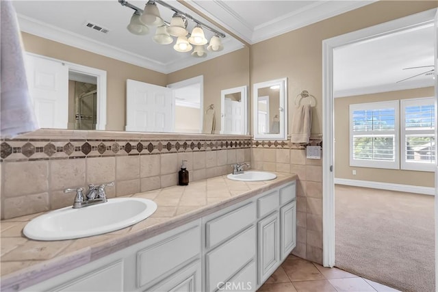 bathroom featuring tile patterned floors, vanity, ornamental molding, and tile walls