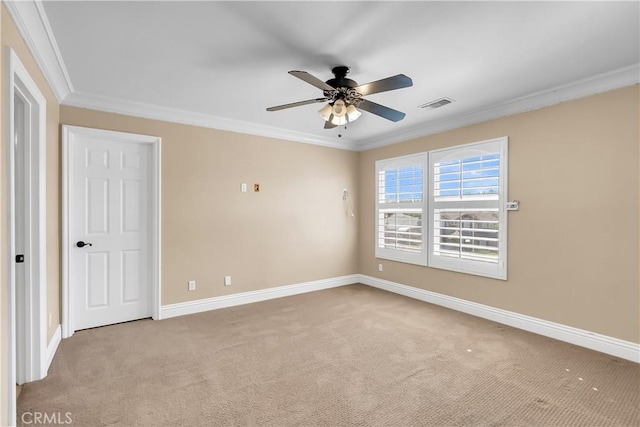 spare room with ceiling fan, ornamental molding, and light carpet