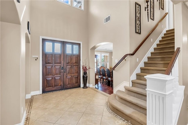 tiled entrance foyer featuring a high ceiling