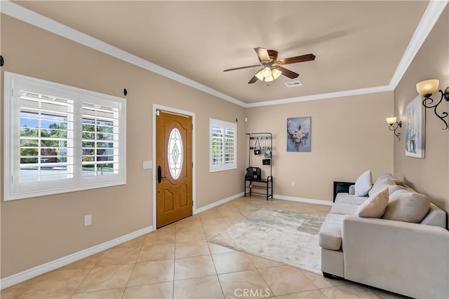 tiled entrance foyer with ceiling fan and ornamental molding