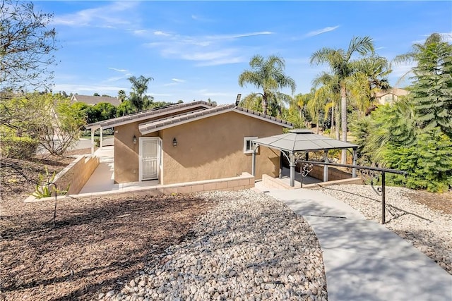 back of property with a gazebo