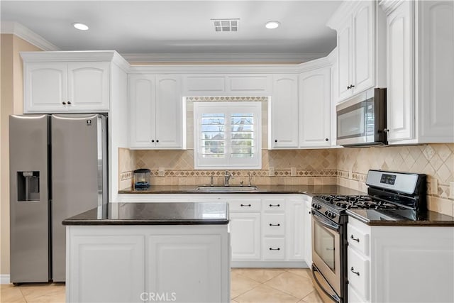 kitchen featuring sink, decorative backsplash, ornamental molding, white cabinetry, and stainless steel appliances