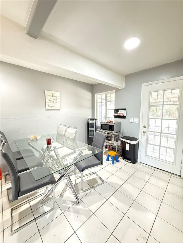 dining room featuring plenty of natural light, beamed ceiling, and tile patterned floors