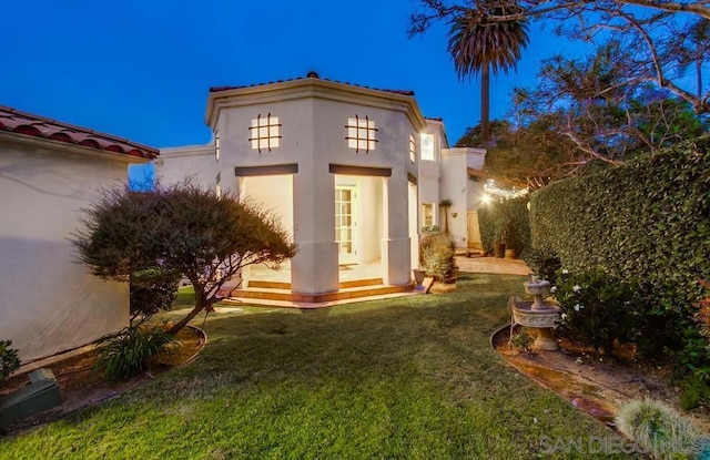 rear view of house featuring a lawn