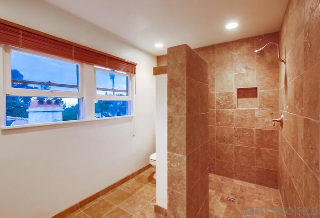 bathroom with toilet and a tile shower