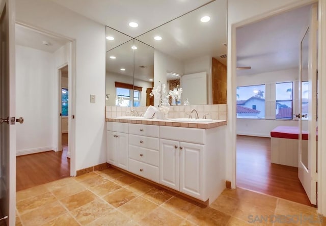 bathroom featuring hardwood / wood-style floors, vanity, and tasteful backsplash