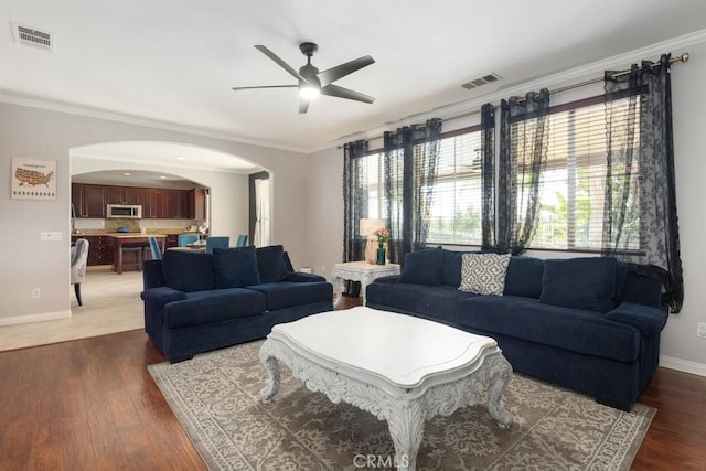 living room with crown molding, ceiling fan, and dark hardwood / wood-style floors