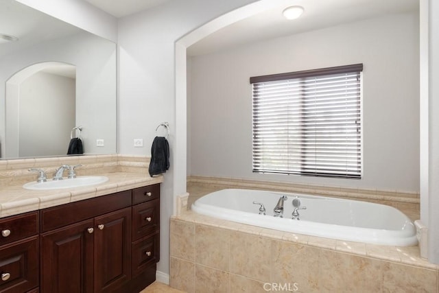 bathroom featuring vanity and tiled bath