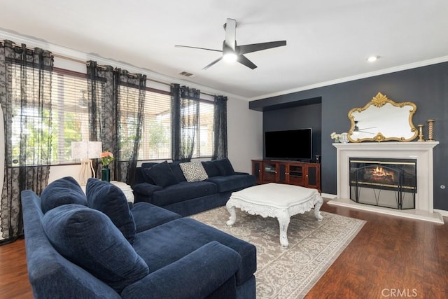 living room with dark hardwood / wood-style flooring, ceiling fan, and ornamental molding