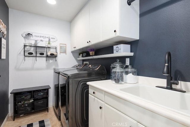 washroom with cabinets, washing machine and dryer, light tile patterned flooring, and sink