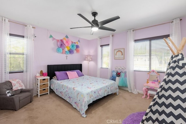 bedroom with light carpet, multiple windows, and ceiling fan