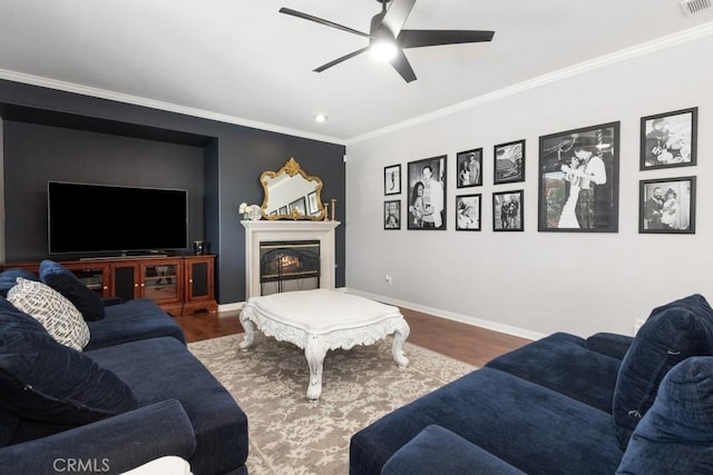 living room with hardwood / wood-style floors, ceiling fan, and ornamental molding