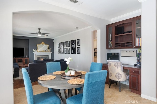 dining area featuring light tile patterned floors, ceiling fan, and crown molding