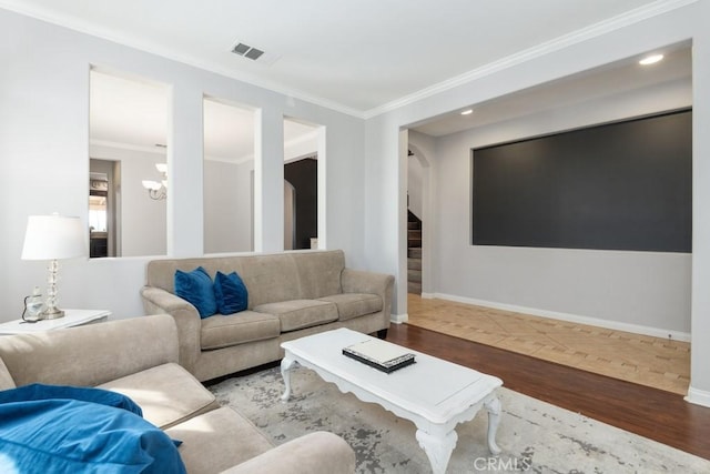 living room featuring a chandelier, wood-type flooring, and ornamental molding