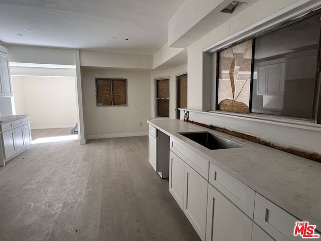 kitchen with hardwood / wood-style floors, white cabinets, and sink