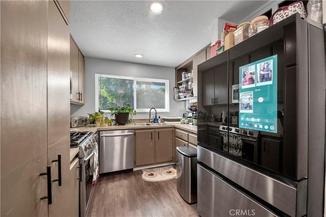 kitchen featuring dark hardwood / wood-style flooring, a textured ceiling, stainless steel appliances, and sink