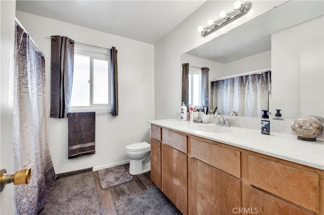 bathroom featuring hardwood / wood-style floors, vanity, a healthy amount of sunlight, and toilet