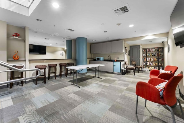 game room with sink and light carpet