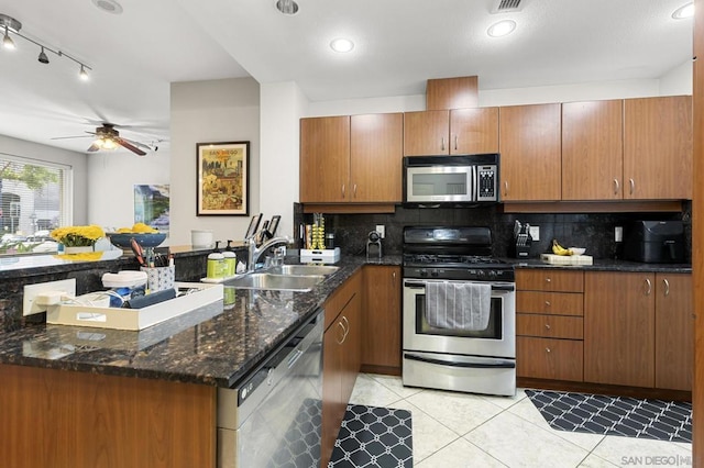 kitchen featuring decorative backsplash, appliances with stainless steel finishes, ceiling fan, and sink