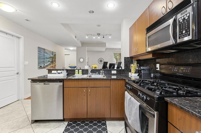 kitchen featuring dark stone counters, tasteful backsplash, sink, and stainless steel appliances