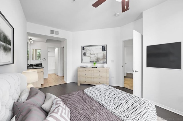 bedroom featuring connected bathroom, ceiling fan, and light hardwood / wood-style flooring