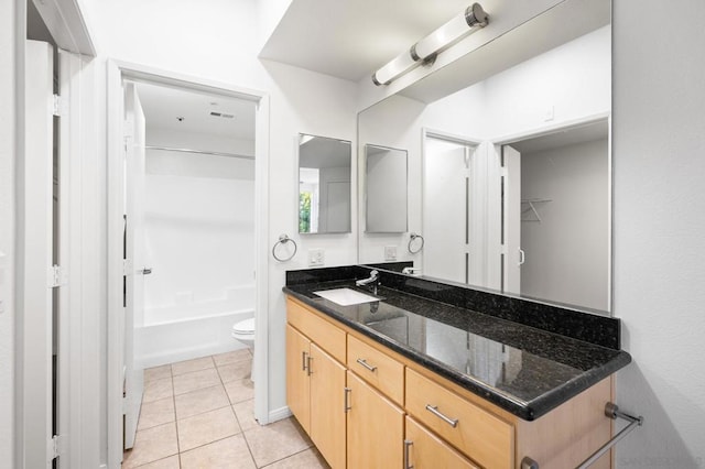 full bathroom featuring toilet, vanity, tile patterned floors, and  shower combination