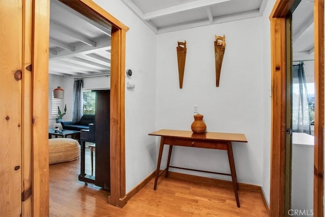 hall featuring beam ceiling and light hardwood / wood-style flooring