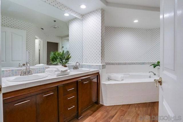 bathroom with vanity, hardwood / wood-style floors, and a bathtub