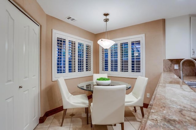 dining area featuring sink and light tile patterned floors