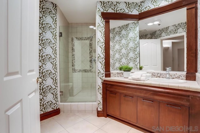 bathroom featuring vanity, a shower with shower door, and tile patterned floors