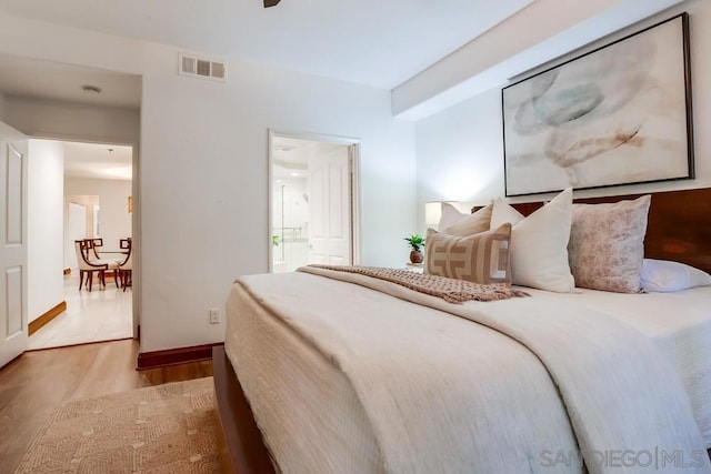 bedroom featuring light hardwood / wood-style floors and ensuite bathroom