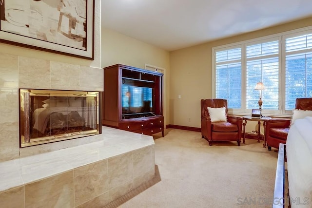 carpeted living room featuring a tiled fireplace