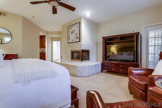 bedroom with a fireplace, carpet floors, and ceiling fan