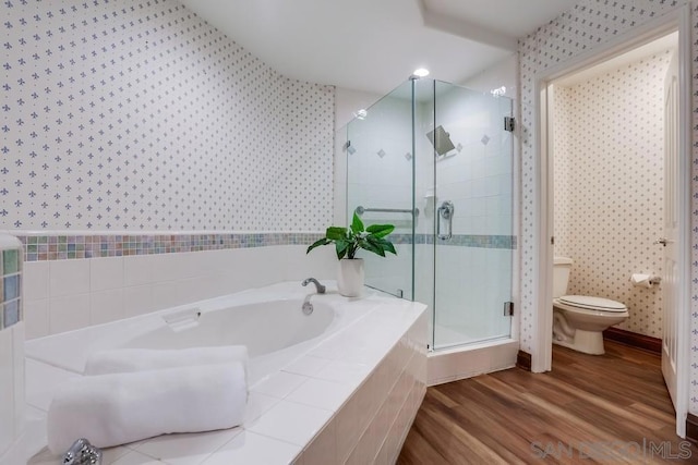 bathroom with wood-type flooring, toilet, and separate shower and tub