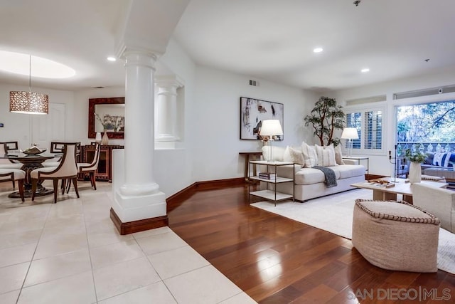 living room with decorative columns and light wood-type flooring