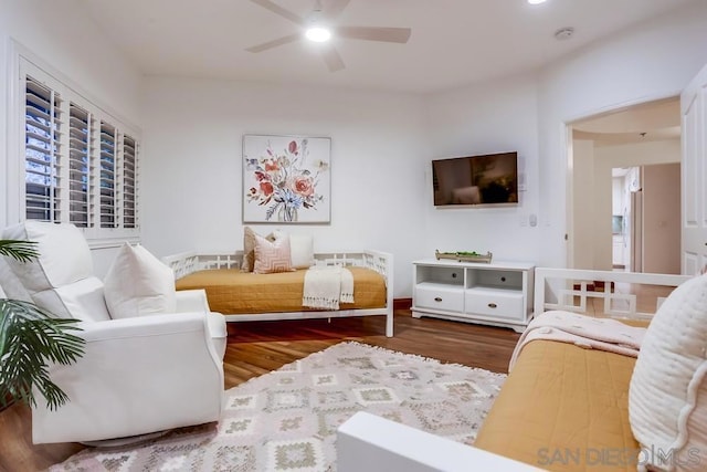 living room featuring wood-type flooring and ceiling fan