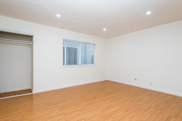 unfurnished bedroom with light hardwood / wood-style flooring and a closet