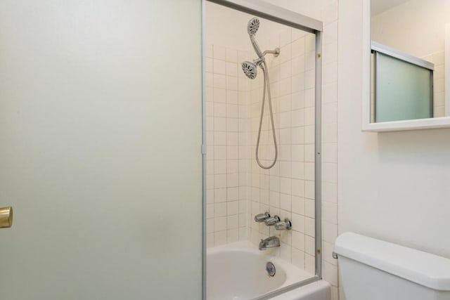 bathroom featuring tiled shower / bath combo and toilet