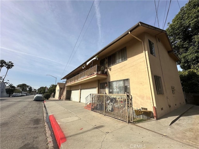 view of side of home featuring a balcony and a garage