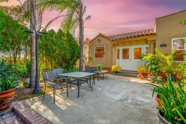 patio terrace at dusk featuring french doors