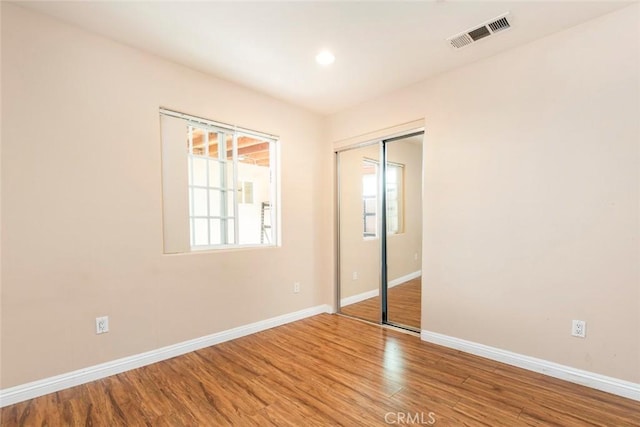 unfurnished bedroom featuring wood-type flooring and a closet