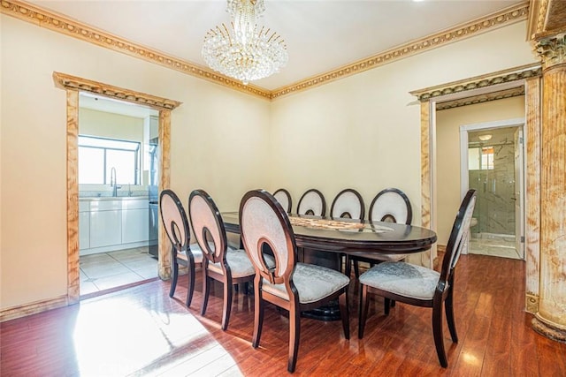 dining room featuring a chandelier, hardwood / wood-style floors, ornamental molding, and sink