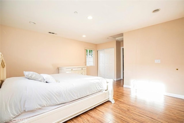 bedroom with light hardwood / wood-style flooring and a closet