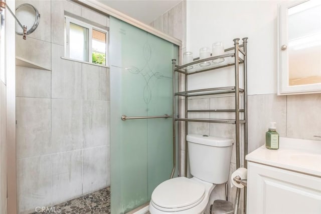 bathroom with an enclosed shower, vanity, and tile walls