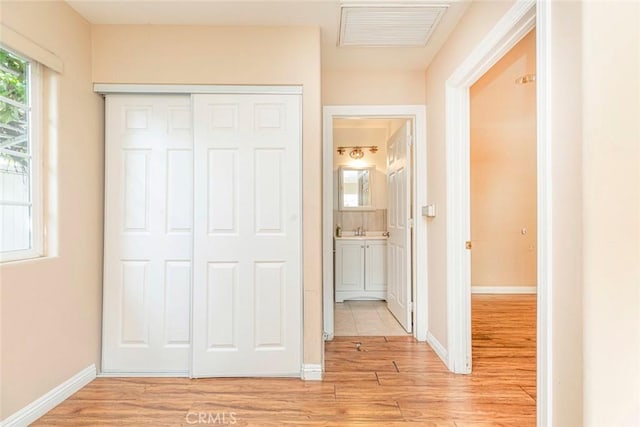 hallway with light hardwood / wood-style flooring and sink